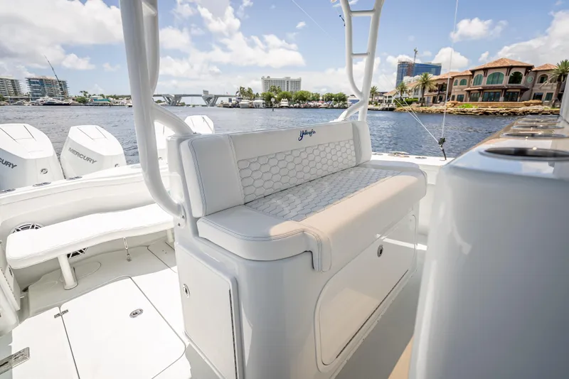 Slide: The Image of 2025 Yellowfin 42 Offshore boat interior with seating, overlooking waterfront homes and clear skies. - 46