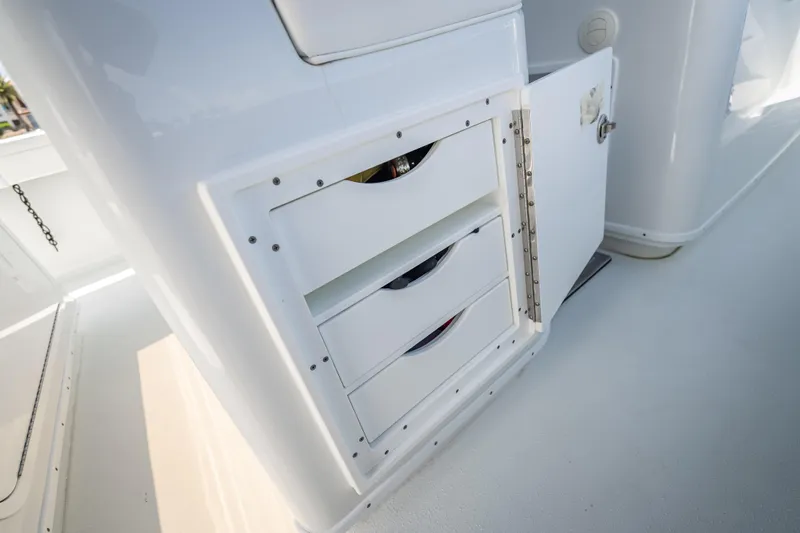 Slide: The Image of 2025 Yellowfin 42 Offshore boat storage compartment with open door and drawers. - 49