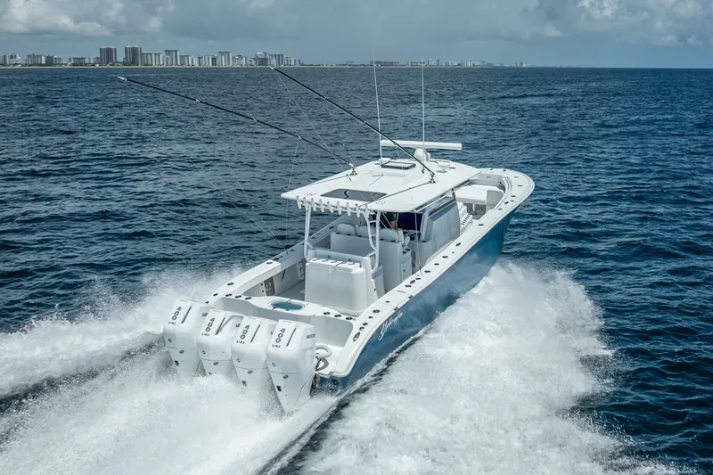 Slide: The Image of 2025 Yellowfin 42 Offshore boat cruising on open ocean near city skyline. - 5