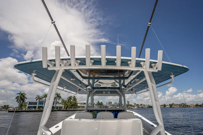 Slide: The Image of 2025 Yellowfin 42 Offshore boat on water, clear sky, palm trees in background. - 53