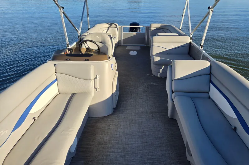 Slide: The Image of 2023 Bennington 22 SSR pontoon boat interior with spacious seating on calm water. - 11