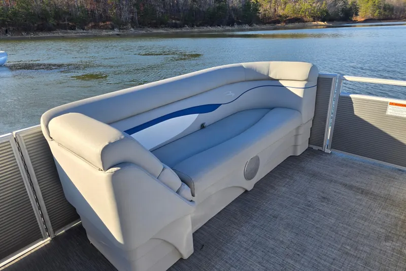 Slide: The Image of 2023 Bennington 22 SSR pontoon boat with comfortable seating on a serene lake. - 13