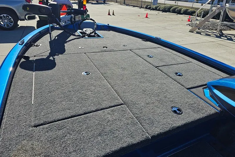 Slide: The Image of 2026 Vexus AVX1880 boat deck with gray carpet and blue trim in a parking area. - 21