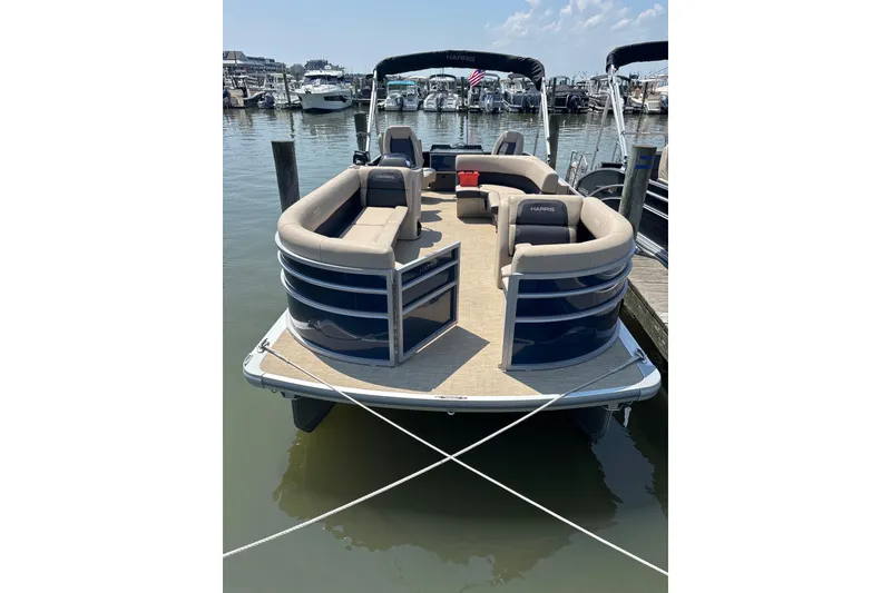 Slide: The Image of 2025 Harris Cruiser 230 pontoon boat docked at marina, featuring spacious seating. - 4