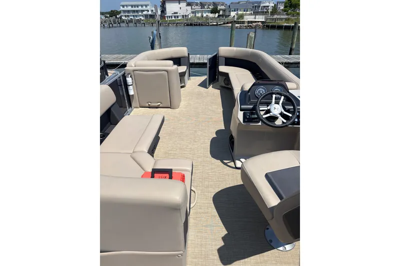 Slide: The Image of 2025 Harris Cruiser 230 pontoon boat interior with beige seating and steering console. - 6