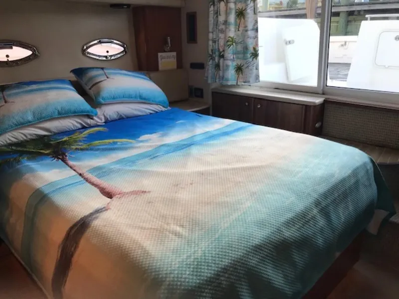 Slide: The Image of Luxurious 2004 Meridian 459 Motoryacht bedroom with beach-themed bedding and scenic window view. - 29