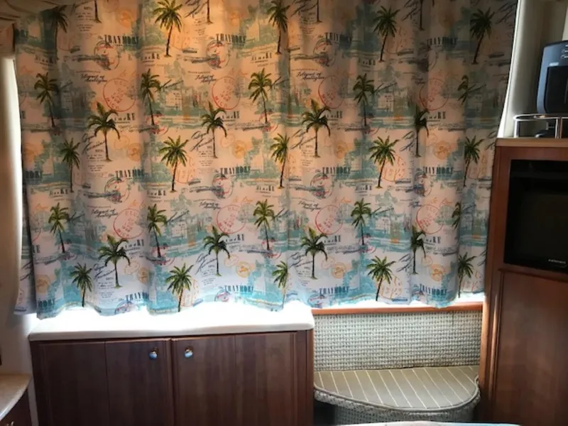 Slide: The Image of Interior of 2004 Meridian 459 Motoryacht with tropical-themed curtains and wooden cabinetry. - 33