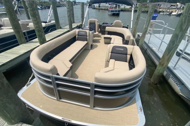 Slide: The Image of 2025 Harris Cruiser 230 pontoon boat docked, featuring spacious seating and modern design. - 3