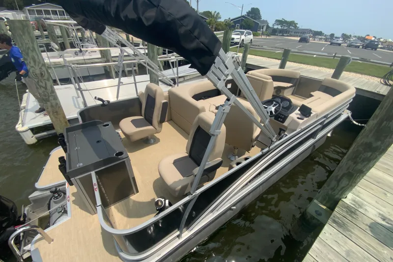 Slide: The Image of 2025 Harris Cruiser 230 pontoon boat docked, featuring spacious seating and modern design. - 4