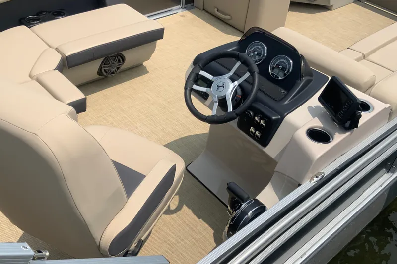 Slide: The Image of 2025 Harris Cruiser 230 boat interior with beige seating and modern dashboard controls. - 7
