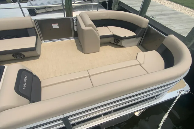 Slide: The Image of 2025 Harris Cruiser 230 pontoon boat with beige seating and spacious deck layout. - 8