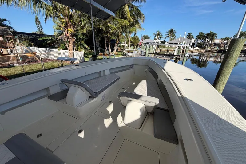 Slide: The Image of 2018 SeaVee 390Z boat interior with seating, docked near palm trees and calm water. - 3