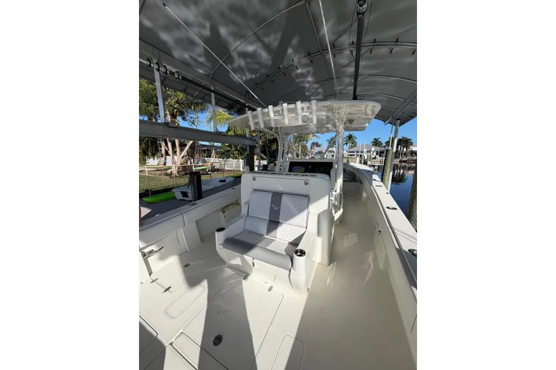 Slide: The Image of 2018 SeaVee 390Z boat interior with seating and canopy, docked by a waterfront. - 4