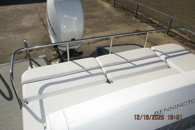 Slide: The Image of 2022 Bennington RX Sport Line boat with white seating and railing, featuring an outboard motor. - 6