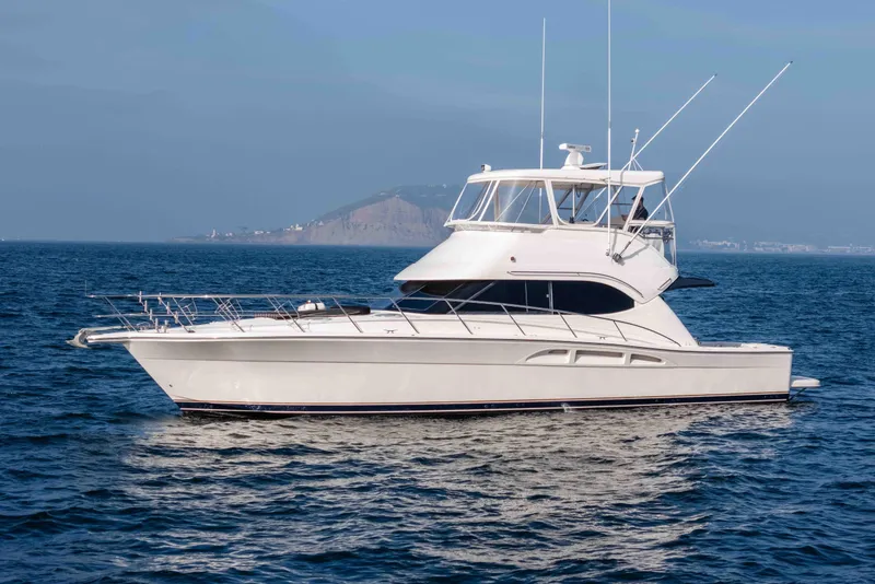 The Image of 2005 Riviera 47 Convertible yacht cruising on open sea. - 0