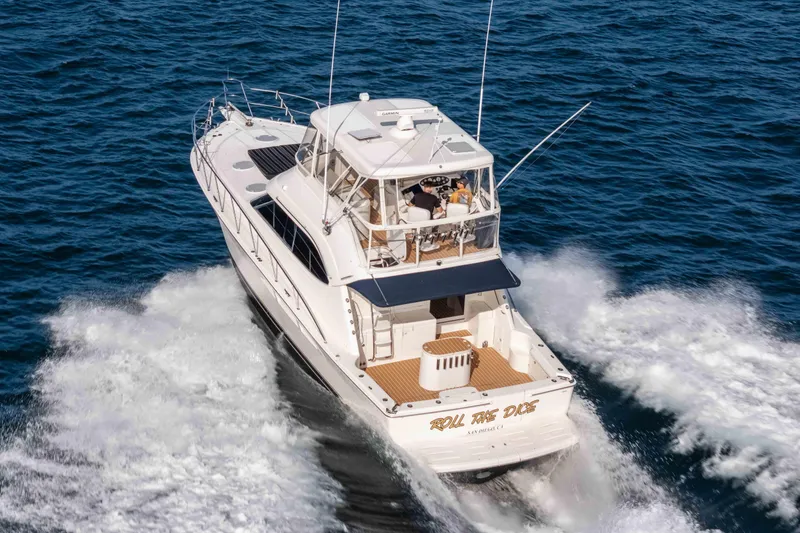 Slide: The Image of 2005 Riviera 47 Convertible yacht cruising on open water, rear view. - 2