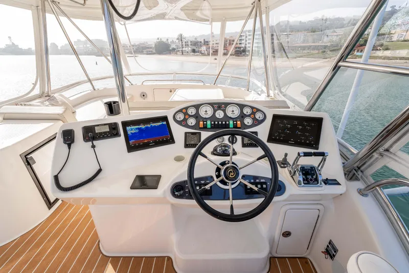 Slide: The Image of Cockpit of 2005 Riviera 47 Convertible yacht with steering wheel and navigation controls. - 21