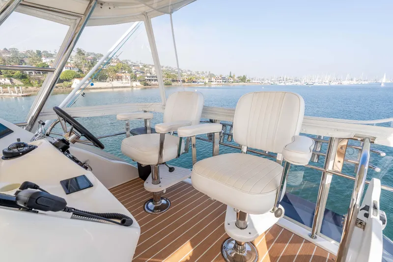 Slide: The Image of Helm of 2005 Riviera 47 Convertible yacht with ocean view and white captain chairs. - 22