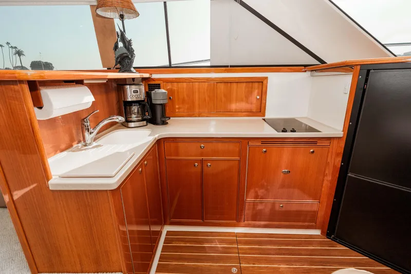 Slide: The Image of Luxurious 2005 Riviera 47 Convertible yacht kitchen with wood cabinetry and modern appliances. - 28
