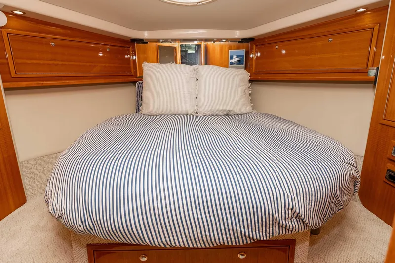 Slide: The Image of Luxurious bedroom interior of 2005 Riviera 47 Convertible yacht with striped bedding. - 30