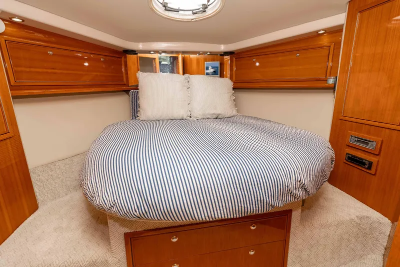 Slide: The Image of Luxurious cabin interior of 2005 Riviera 47 Convertible yacht with striped bedding. - 32