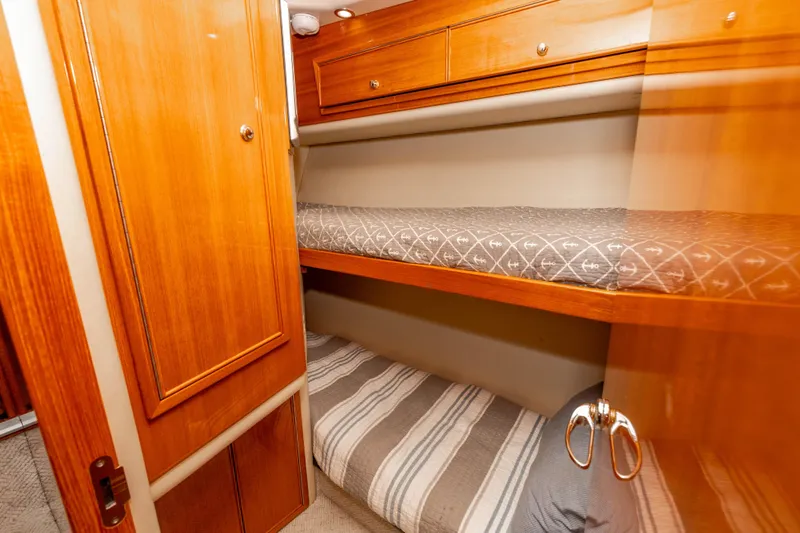 Slide: The Image of 2005 Riviera 47 Convertible yacht interior with wooden bunk beds and storage. - 35