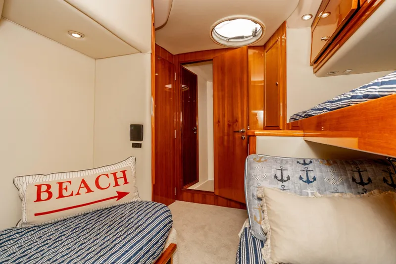 Slide: The Image of 2005 Riviera 47 Convertible yacht cabin with cozy bedding and nautical decor. - 39