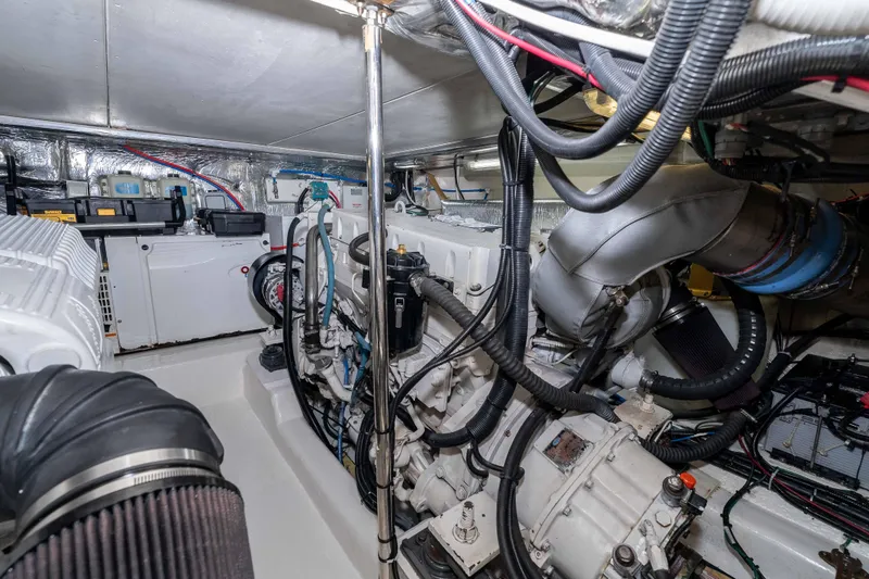 Slide: The Image of Engine room of a 2005 Riviera 47 Convertible yacht, showcasing complex machinery and wiring. - 42