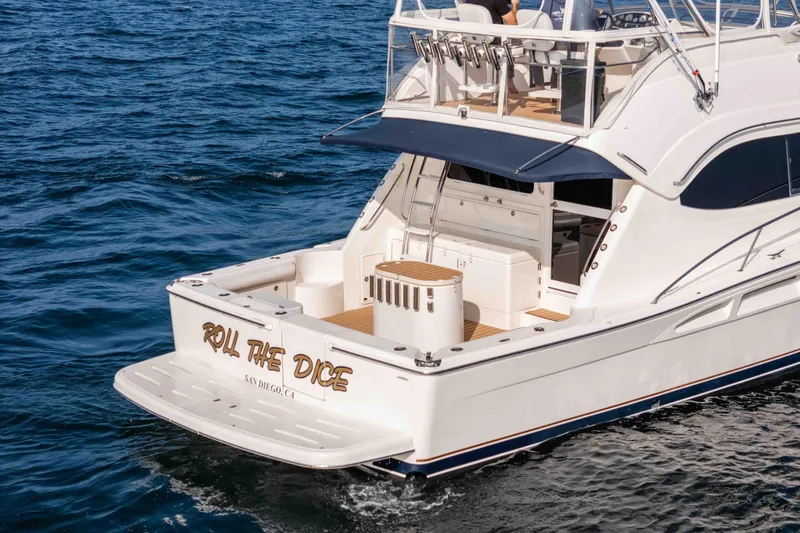 Slide: The Image of 2005 Riviera 47 Convertible yacht named "Roll the Dice" on ocean waters. - 6