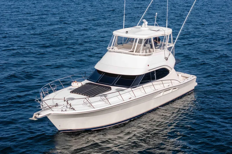 Slide: The Image of 2005 Riviera 47 Convertible yacht cruising on open blue waters. - 8