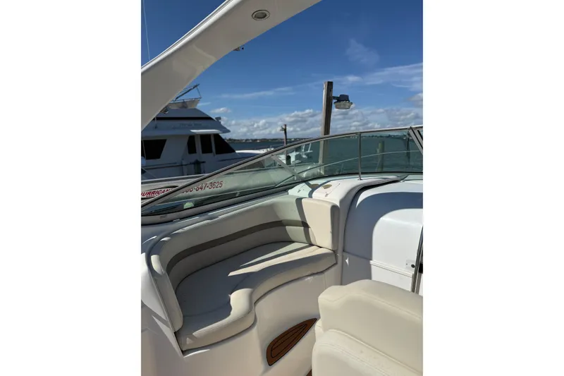 Slide: The Image of 2009 Chaparral 290 Signature boat interior with seating, docked under clear blue skies. - 11