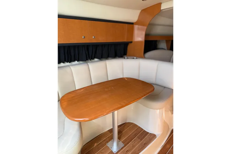 Slide: The Image of 2009 Chaparral 290 Signature cabin interior with wooden table and cushioned seating. - 12
