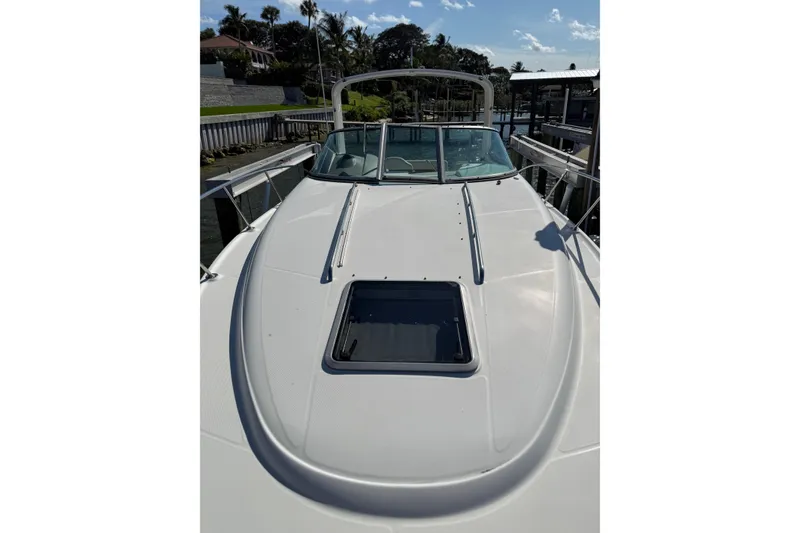 Slide: The Image of 2009 Chaparral 290 Signature boat docked, showcasing sleek white deck and windshield. - 18