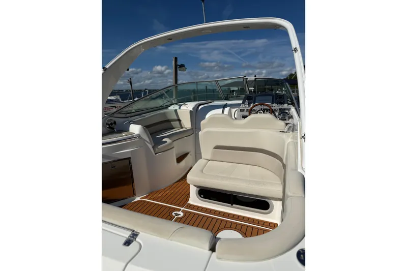 Slide: The Image of 2009 Chaparral 290 Signature boat interior with seating and dashboard under blue sky. - 4