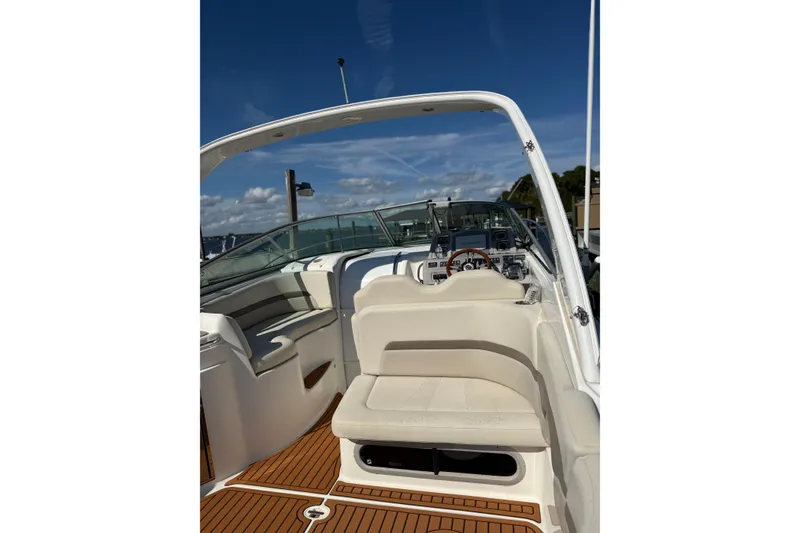 Slide: The Image of 2009 Chaparral 290 Signature boat interior with seating and dashboard under clear blue sky. - 5