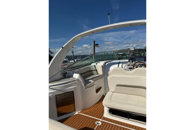 Slide: The Image of 2009 Chaparral 290 Signature boat interior with seating and helm under clear blue sky. - 6