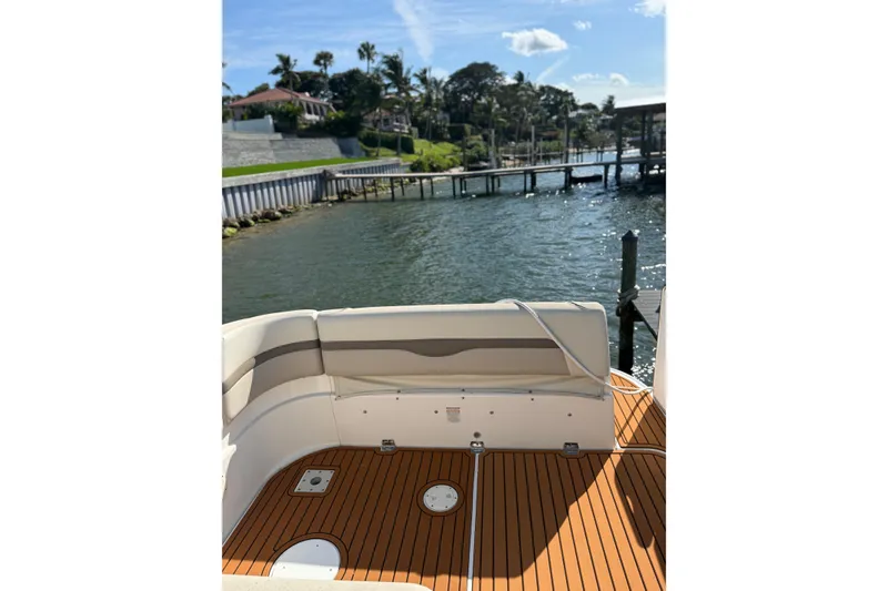 Slide: The Image of 2009 Chaparral 290 Signature boat with teak deck, docked by a scenic waterfront. - 7