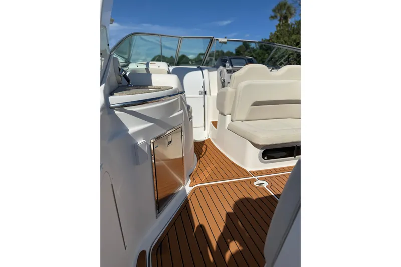 Slide: The Image of 2009 Chaparral 290 Signature boat interior with teak flooring and white seating. - 8