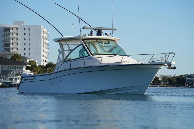 Slide: The Image of 2024 Grady-White Express 330 boat on water, with cityscape background. - 14