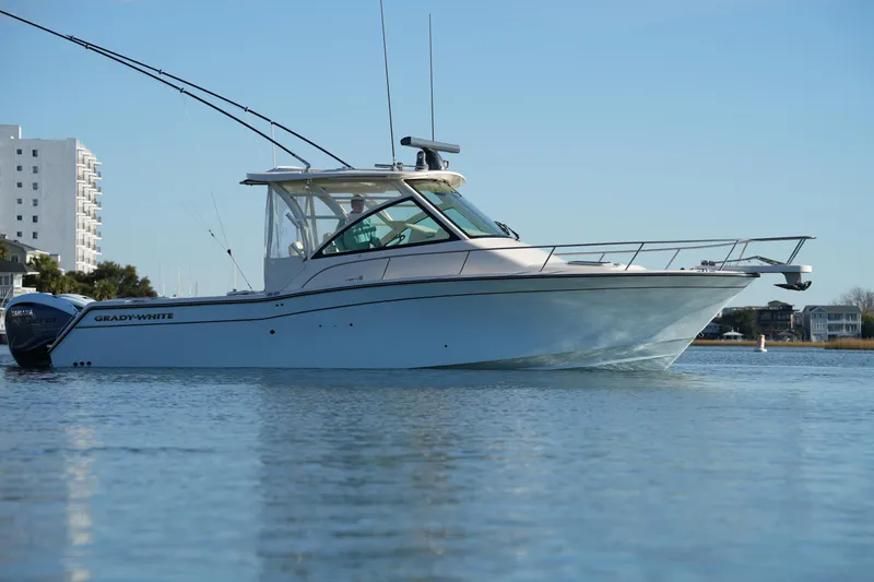 Slide: The Image of 2024 Grady-White Express 330 boat on calm water, side view. - 17