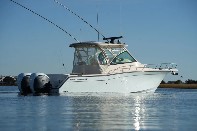 Slide: The Image of 2024 Grady-White Express 330 boat on calm water, featuring dual Yamaha engines. - 22