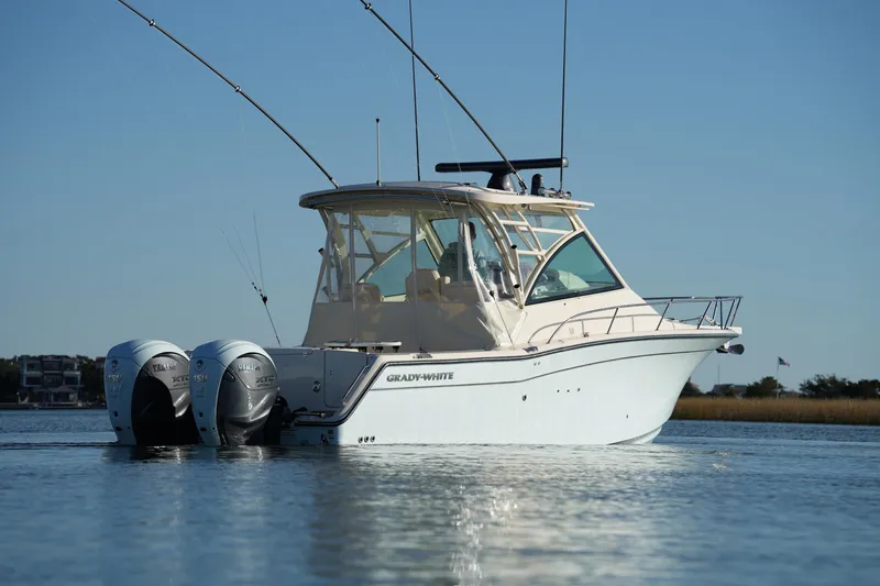 Slide: The Image of 2024 Grady-White Express 330 boat on calm water, featuring dual Yamaha engines. - 24