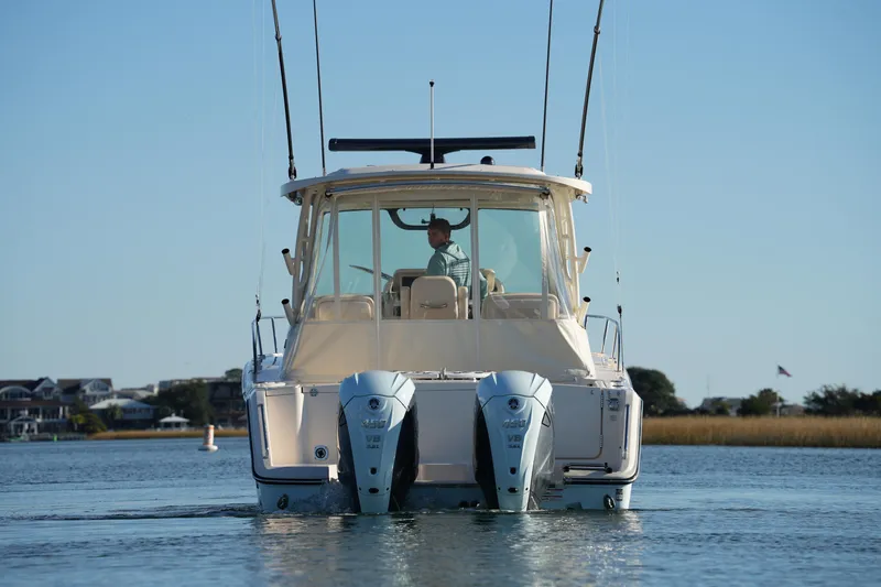 Slide: The Image of 2024 Grady-White Express 330 boat on calm water, rear view with dual engines. - 29