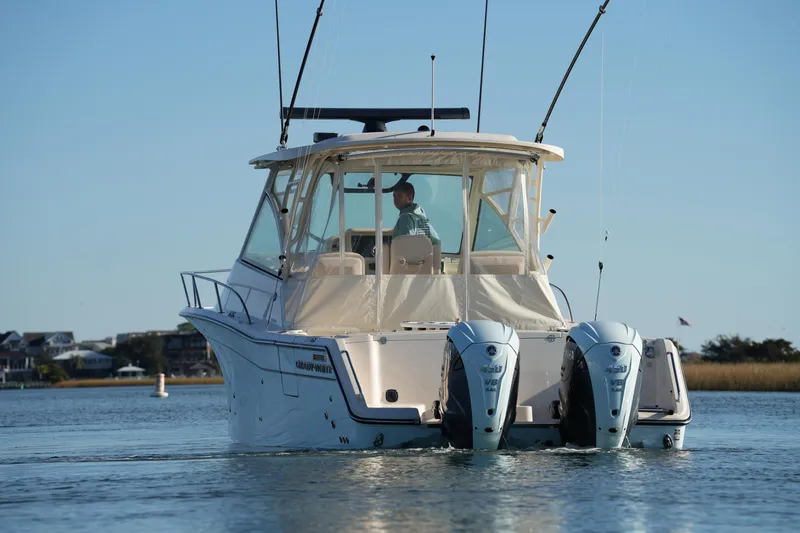 Slide: The Image of 2024 Grady-White Express 330 boat on calm water, rear view with dual engines. - 30