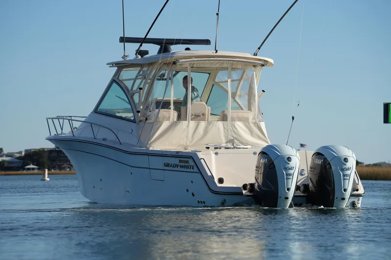 Slide: The Image of 2024 Grady-White Express 330 boat with dual Yamaha engines on calm water. - 31
