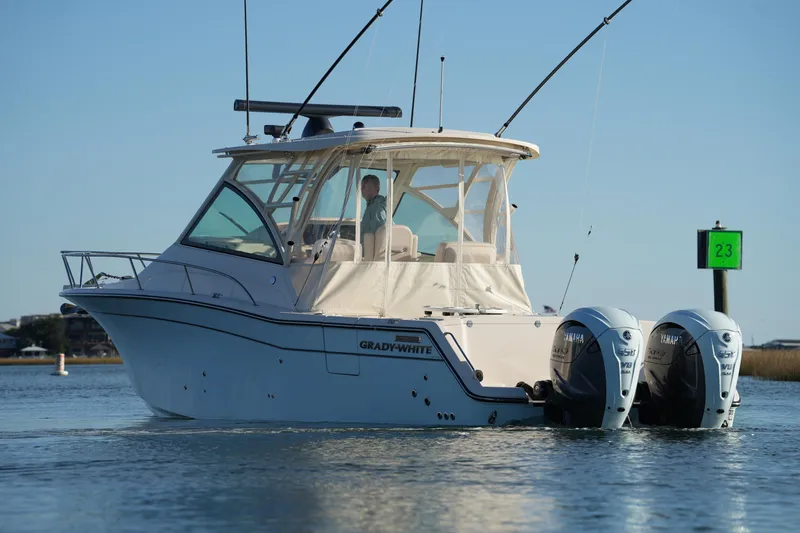 Slide: The Image of 2024 Grady-White Express 330 boat with dual Yamaha engines on calm water. - 32
