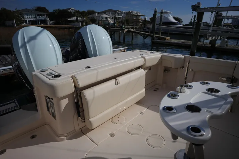 Slide: The Image of 2024 Grady-White Express 330 boat interior with dual engines and fishing rod holders. - 33