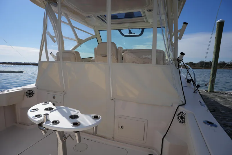 Slide: The Image of 2024 Grady-White Express 330 boat interior with fishing rod holders, docked by the water. - 40