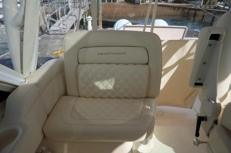 Slide: The Image of 2024 Grady-White Express 330 boat seat with quilted upholstery, dockside view. - 47