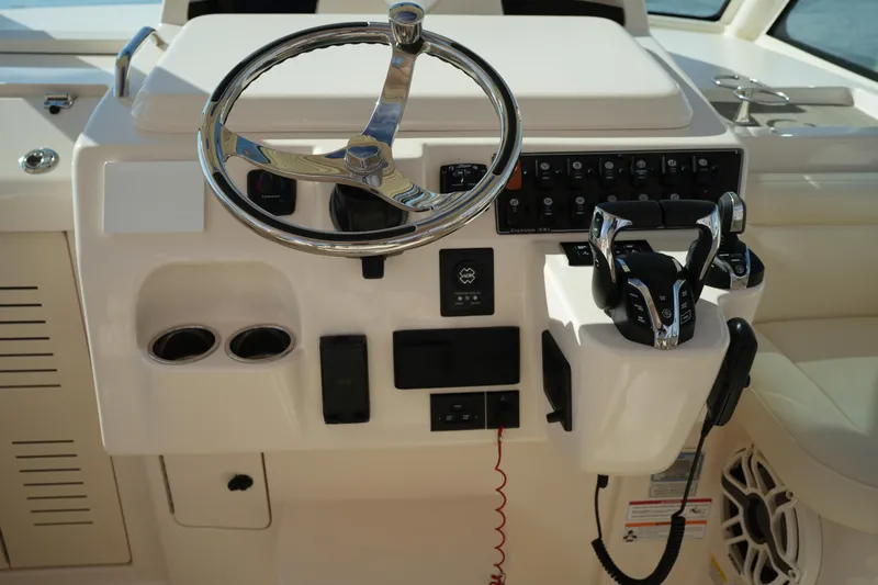 Slide: The Image of 2024 Grady-White Express 330 helm with steering wheel and controls. - 50